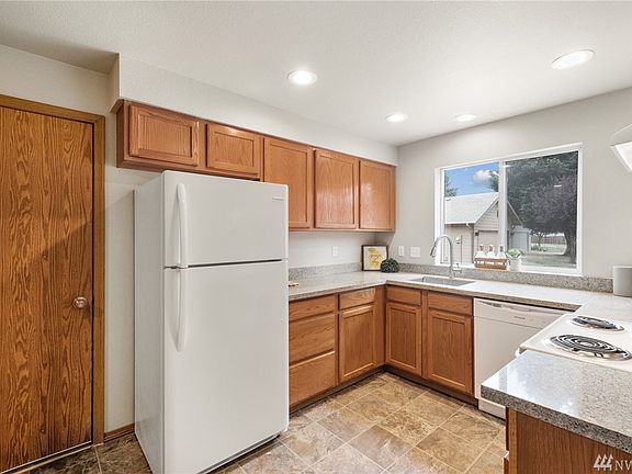 The cheerful kitchen has been tastefully updated with new quartz counters and an undermount stainless sink. 