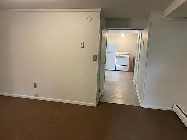 View of hall to kitchen from living room/door to bedroom