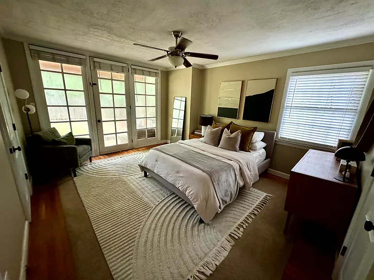 Primary bedroom with ensuite bathroom at back of house with small screened-in deck area.