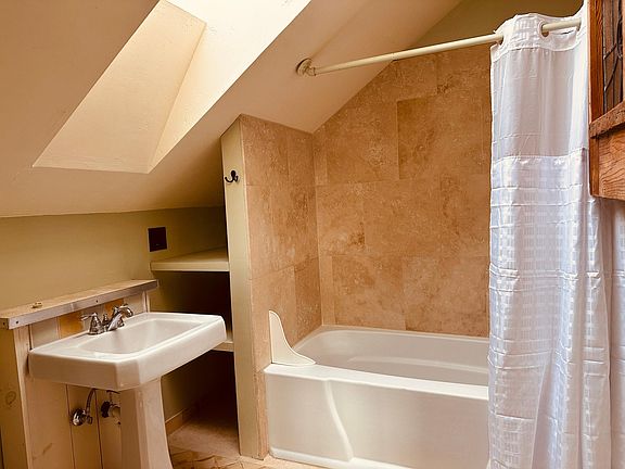 Bathroom with tub/shower combo and skylight