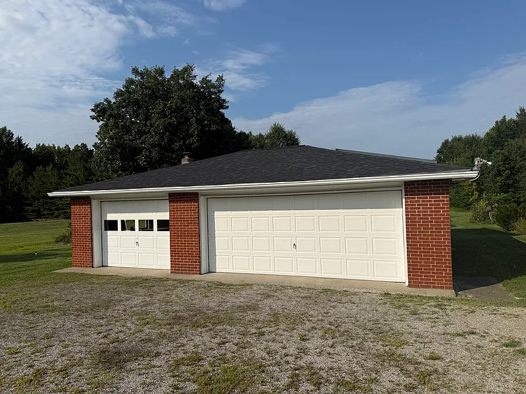 Detached two car garage and additional workshop. Behind the garage there is additional storage for lawn tractors or other equipment.
