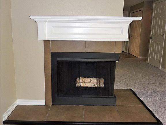 Beautiful white mantel over your corner wood burning fireplace