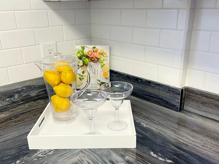 Step into a realm of timeless sophistication in our studio apartments, where gleaming white subway-tiled backsplash weaves classic elegance into contemporary style.