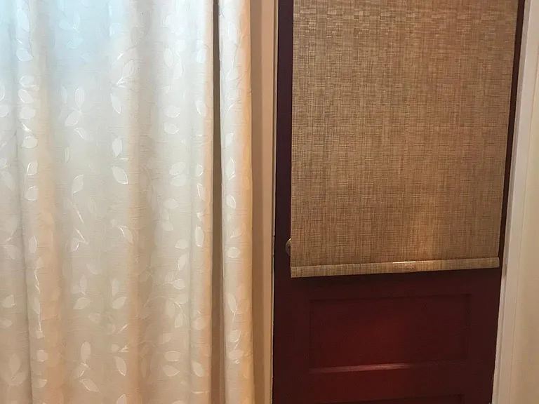 just inside breakfast room showing an exit door onto a patio area outside. Also, there are draped windows on two sides of the breakfast/utility room.