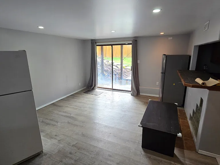 Lower level living /family room/den/game room. Leads out to backyard