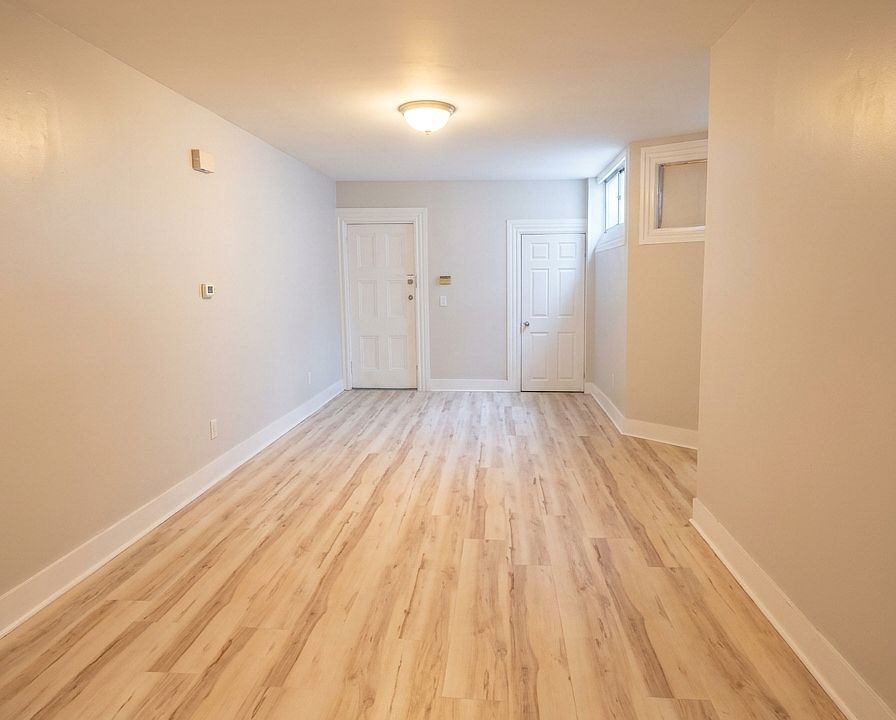 Living room vacant. Spacious main living area with updated flooring and a long, flexible layout with plenty of room for living and dining furniture.