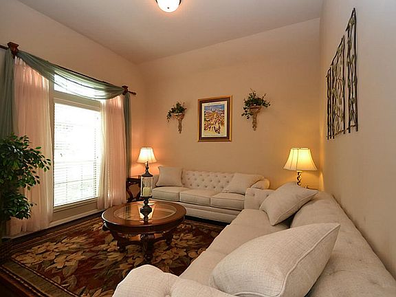 Living room accented by hardwood floors and raised ceilings.