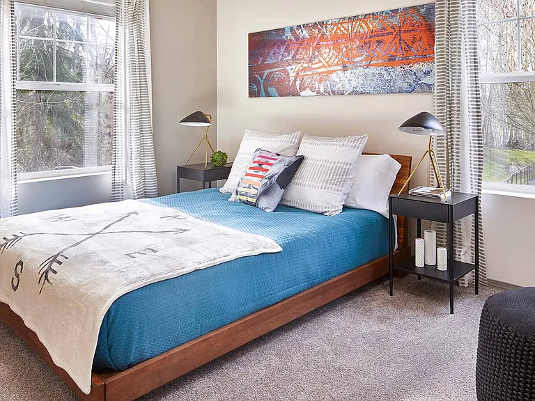 Spacious apartment bedroom with plush carpet flooring.