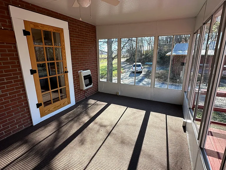 Sunroom. Door shown on left is entrance to kitchen. Deck is on the right side.