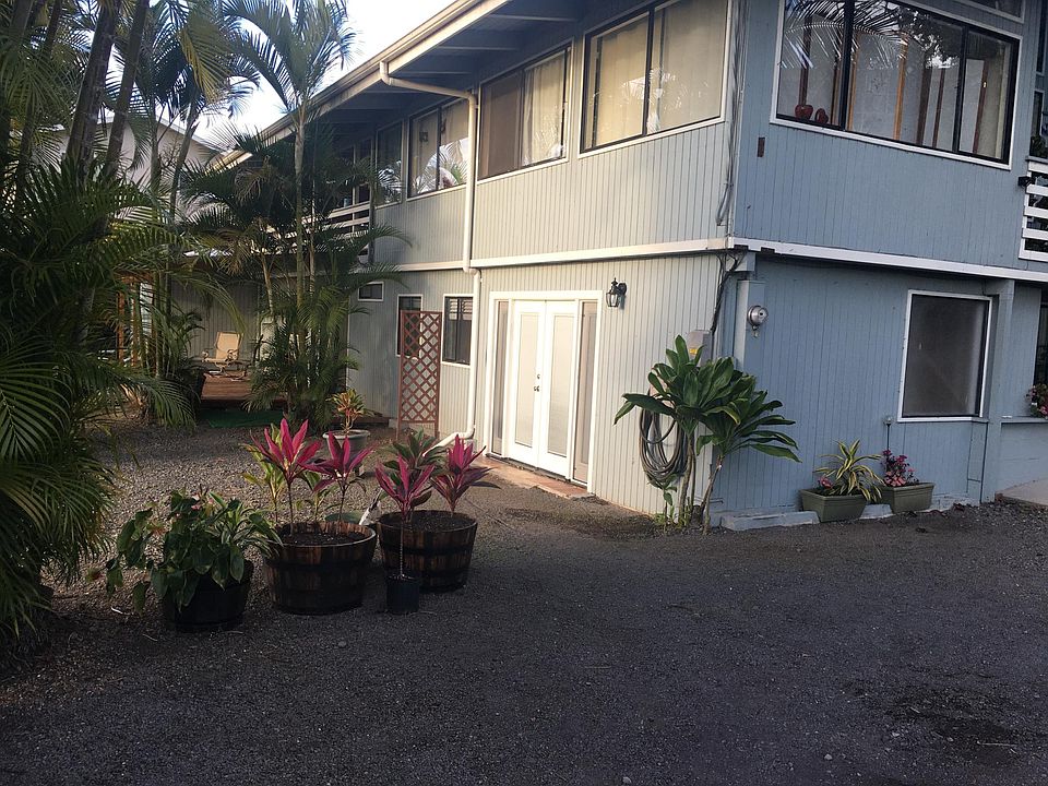 Large gravel off street parking area, leading to front door of apartment