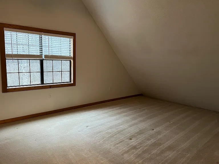 Large upstairs bedroom - vaulted/V shaped ceiling. Double window allows in natural light. *Note: since this picture was taken, a new split air conditioning unit has been added above windows.