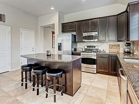 Open concept living floorplan. Light and bright kitchen with granite breakfast bar/island and stainless appliances.
