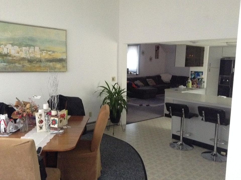Dining room is first room you walk into, with area for seating at kitchen counter, that has extra wide countertops