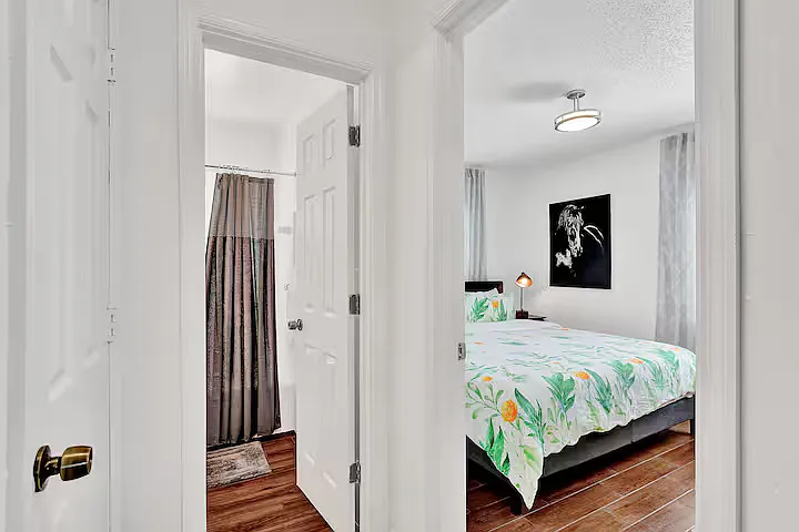 Bathroom with tub next to bedroom with king size bed