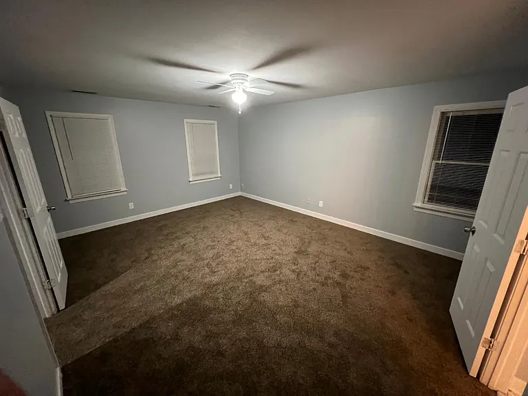 Master bedroom, door to the right is the master bathroom and door on the left is to the hallway. 2 windows on the left face the front of the home, window to the right faces the side.