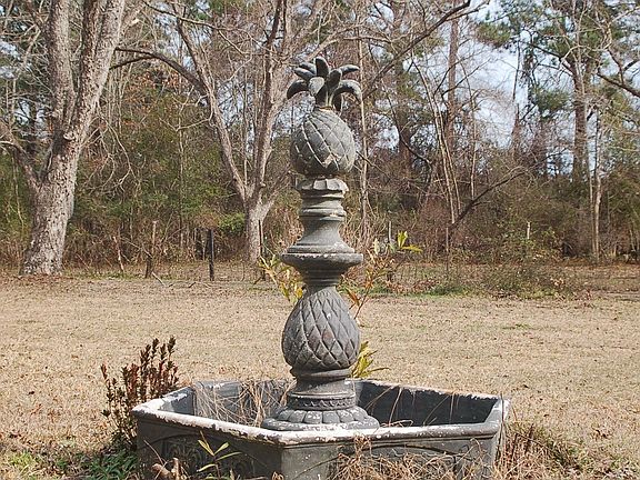 Ornamental fountain in front of farmhouse