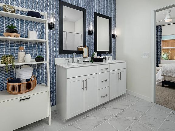 Primary bath with chrome fixtures and black-framed mirrors