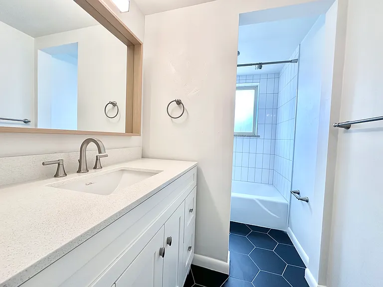 Contemporary bathroom with sleek vanity, elegant fixtures, and inviting bathtub under natural light. Contemporary bathroom with sleek vanity, elegant fixtures, and inviting bathtub under natural light.