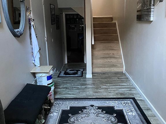 Front entryway looking in. Stairway on right to 2nd floor. 3rd bedroom/den straight ahead. Entry to garage on the left. Carpet on stairs has been changed. See other stair photos for what is on stair treads now.