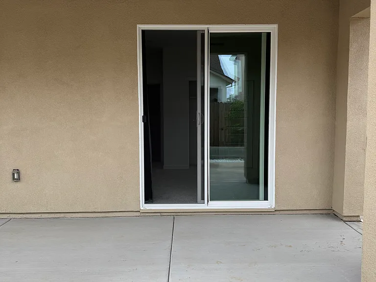 View from backyard patio looking towards the bedroom sliding glass door.