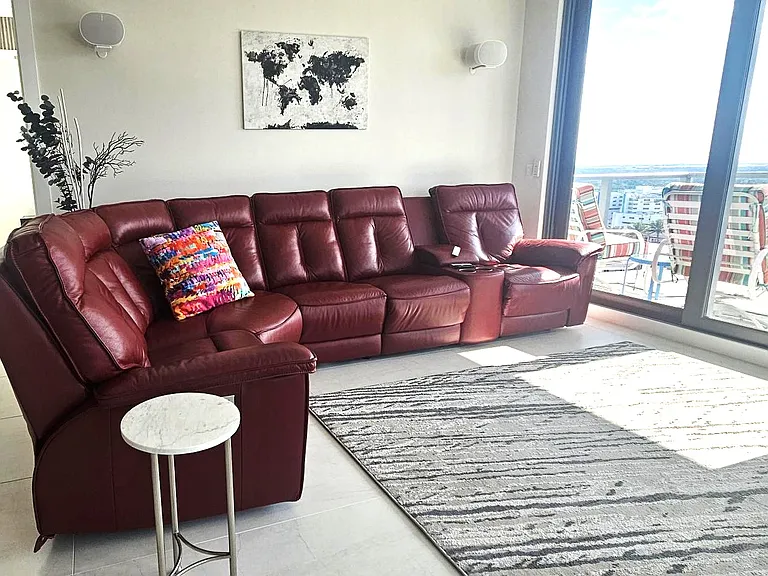 main room with leather couch with three seats with lumbar, head and foot rests