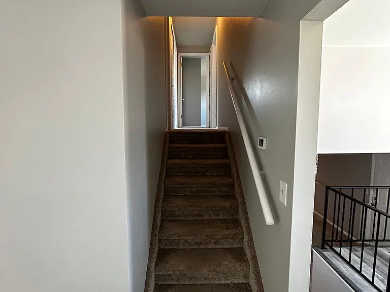 stairs from first floor leading to the kitchen and stairs leading upstairs to bedrooms.