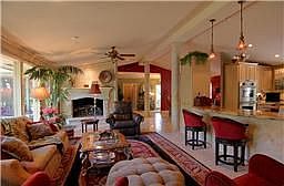 Kitchen overlooks magnificant den with huge custom fireplace.