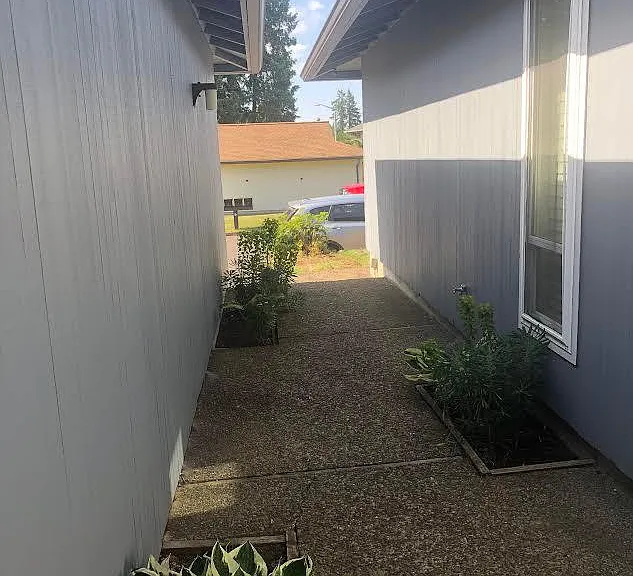 Entry sidewalk to front door adjacent to garage wall