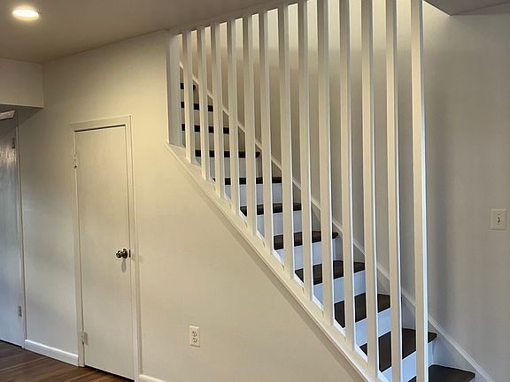 Living room area with recessed lighting and stairs to upper level