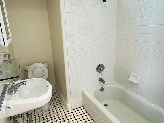 New and clean bathroom with black and white tile. Medicine cabinet. Free standing sink.
