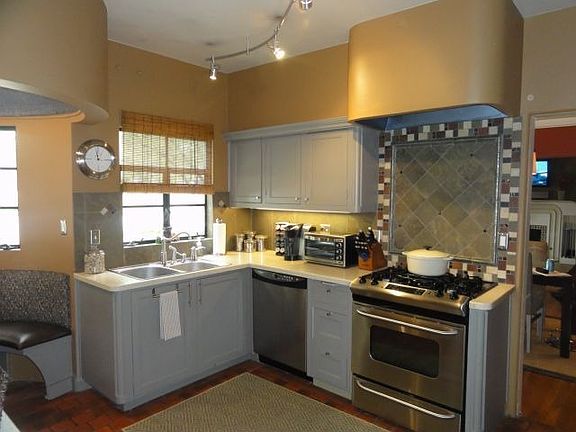 KITCHEN WITH STAINLESS APPLIANCES AND CORIAN TOPS