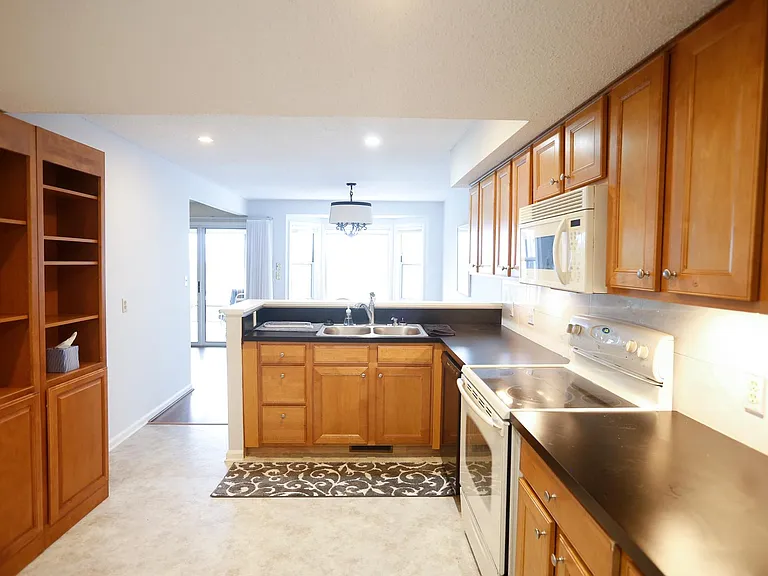 Kitchen, formica counter tops, vinyl floor. Undercabinet lighting, DW/Microwave over Electric cook top/Black refrigerator/Garbage disposer/ Pantry