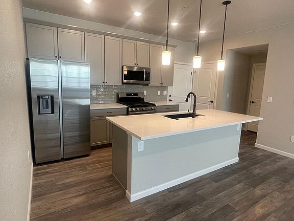 Kitchen with Quartz Countertops, Stainless Steel Appliances and a separate Pantry