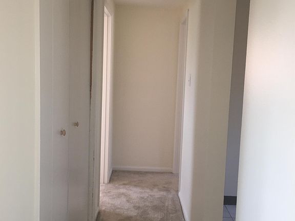 Hallway that leads to Bedrooms with Pantry off the kitchen