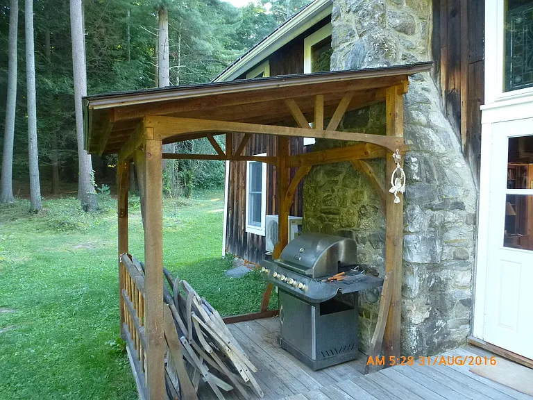 Covered outdoor grill - also where the firewood is stored during the winter.