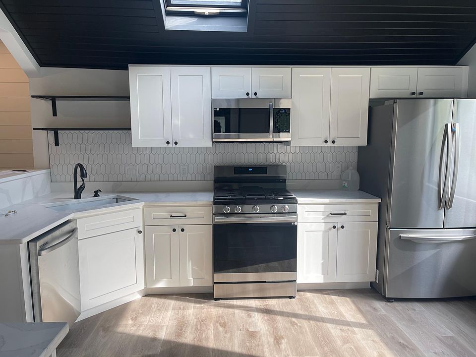 New spacious kitchen that features brand new Samsung appliances, granite counter tops, new cabinets and skylight.
