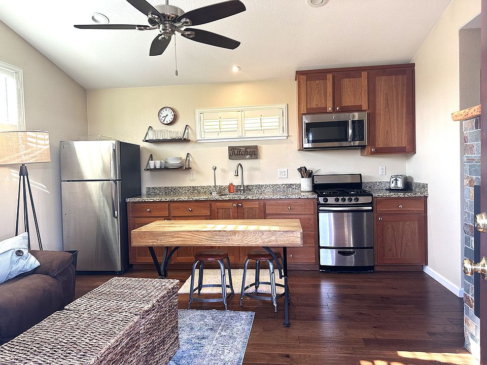 The Kitchen features a gas stove, microwave and refrigerator. Granite counter tops and wood cabinets. Ceiling fan