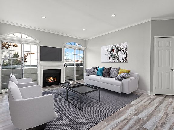 Large living room featuring hardwood floors and natural light providing adjacent patio.