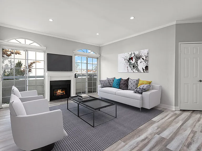 Large living room featuring hardwood floors and natural light providing adjacent patio.