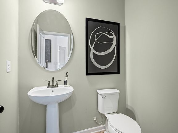 Elegant half bath with pedestal sink and modern fixtures in Langley Overlook townhome in Loganville,