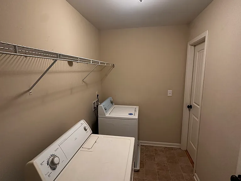 Laundry room, connects upstairs hallway to primary bedroom walking closet