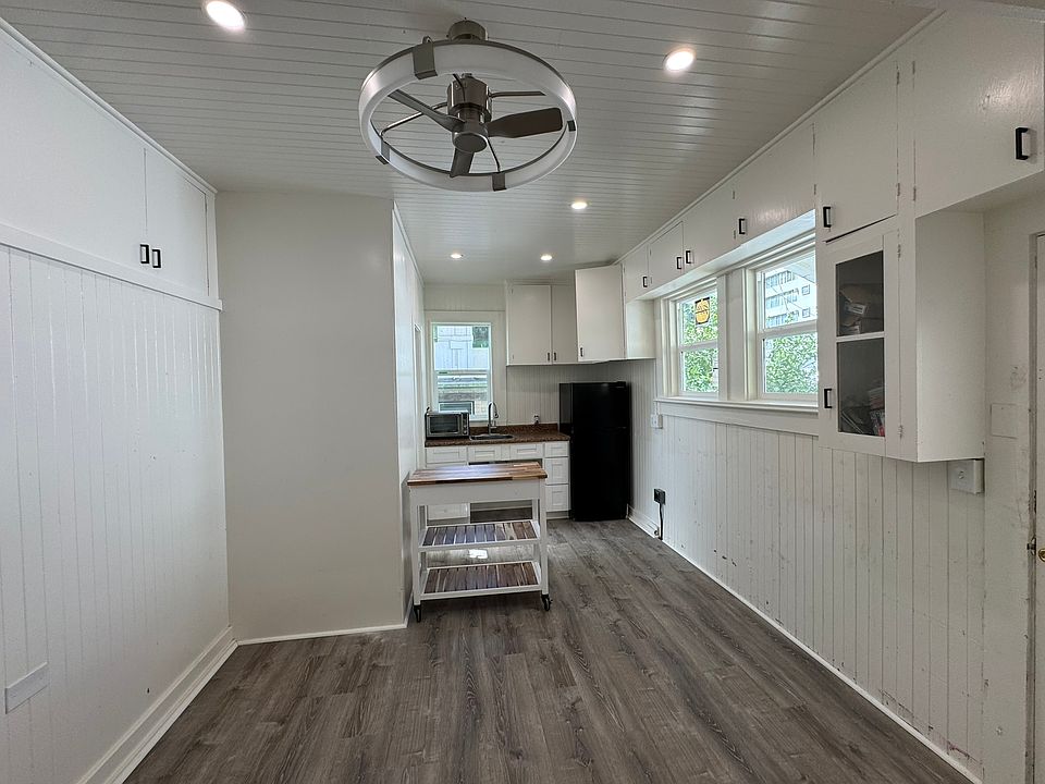 Open living area featuring a kitchenette, new recessed lighting and light fixture, and abundant built-in storage cabinetry.