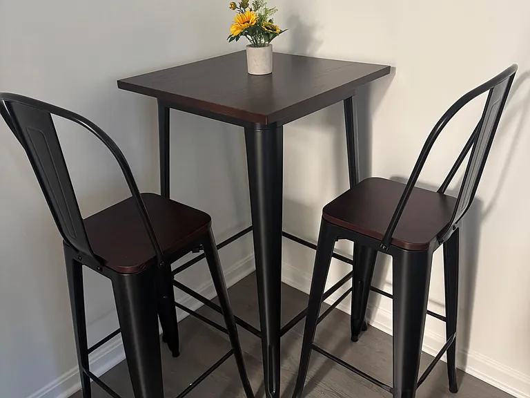 Designated dining nook with a pub-height table and seating for two, ideal for everyday meals or a quick workspace.