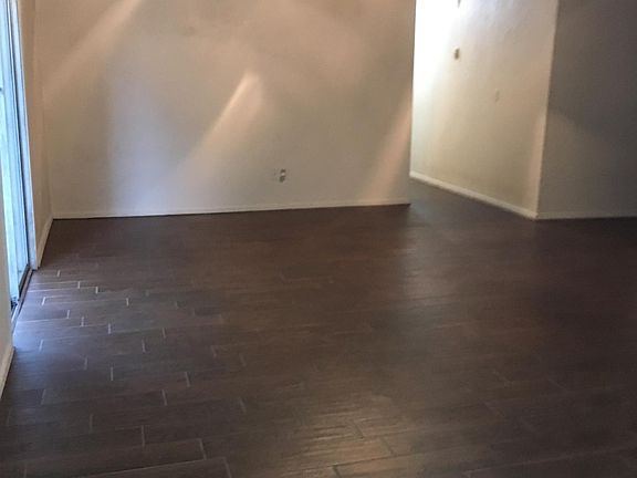 Living Room with Ceiling fan and wood-grained tile flooring.