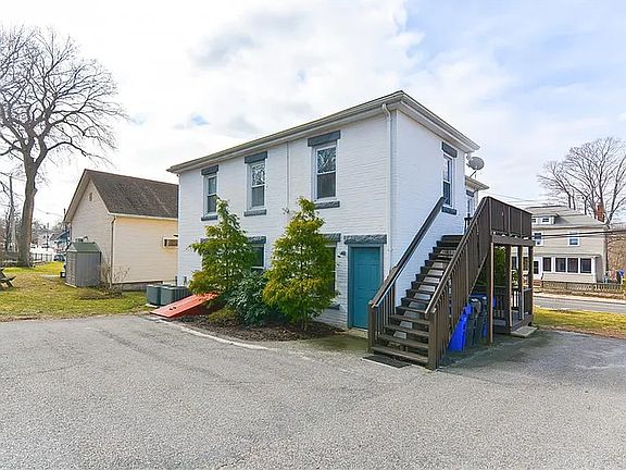 Driveway view and exterior stairs to second floor unit