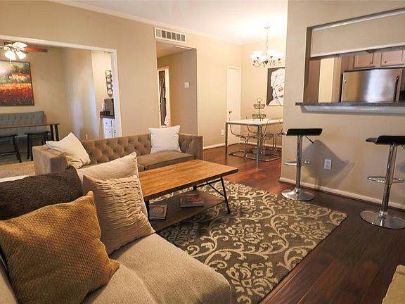 Living room with wood flooring, natural light, and open to the kitchen, office and dining area. (staged photo)