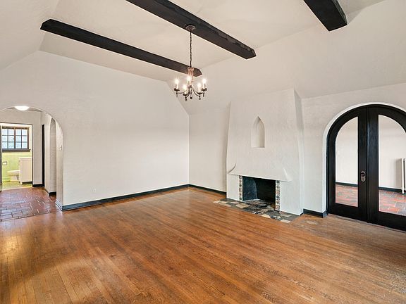 Living room with double wood and glass doors leading to the second bedroom.
