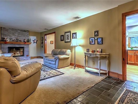 Formal living room with pretty raised hearth brick fireplace welcomes you into this tri-level home!