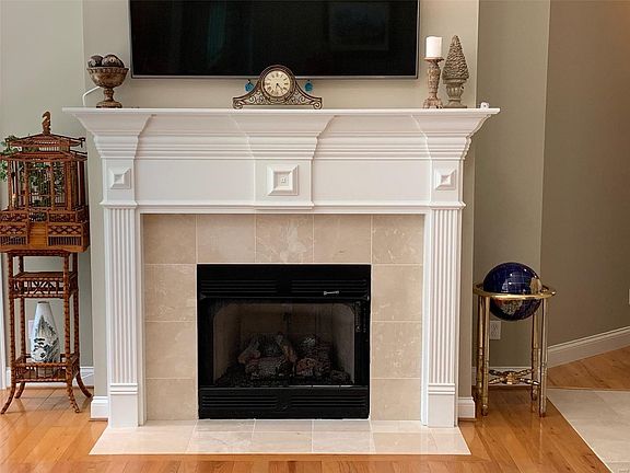Lovely marble accented gas fireplace features a fluted mantel and marble hearth.