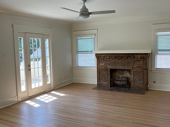 Bright living room with ceiling fan and access to private deck